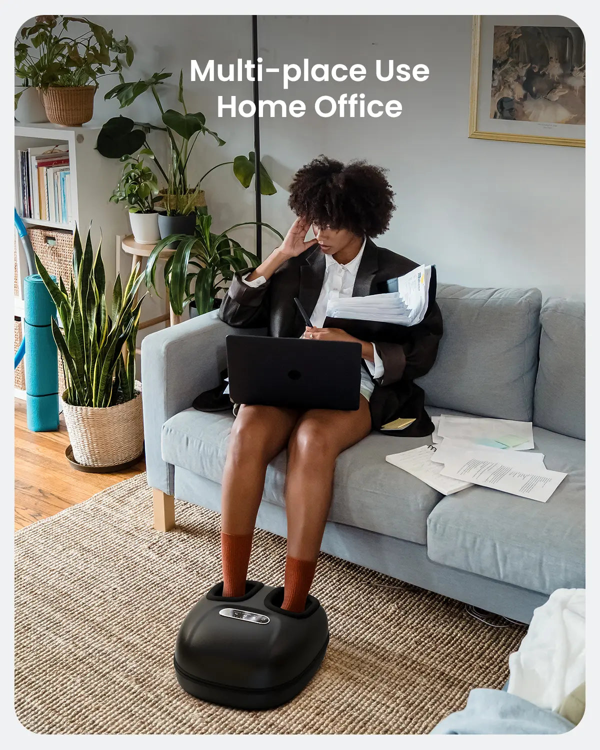 A person sits on a gray sofa in a home office, working on a laptop with papers scattered beside them. One hand supports their head while their feet rest on the Renpho EU Shiatsu Foot Massager Machine [2nd Generation], soothing their sore feet. The background features plants and shelves, and text at the top reads, "Multi-place Use Home Office.